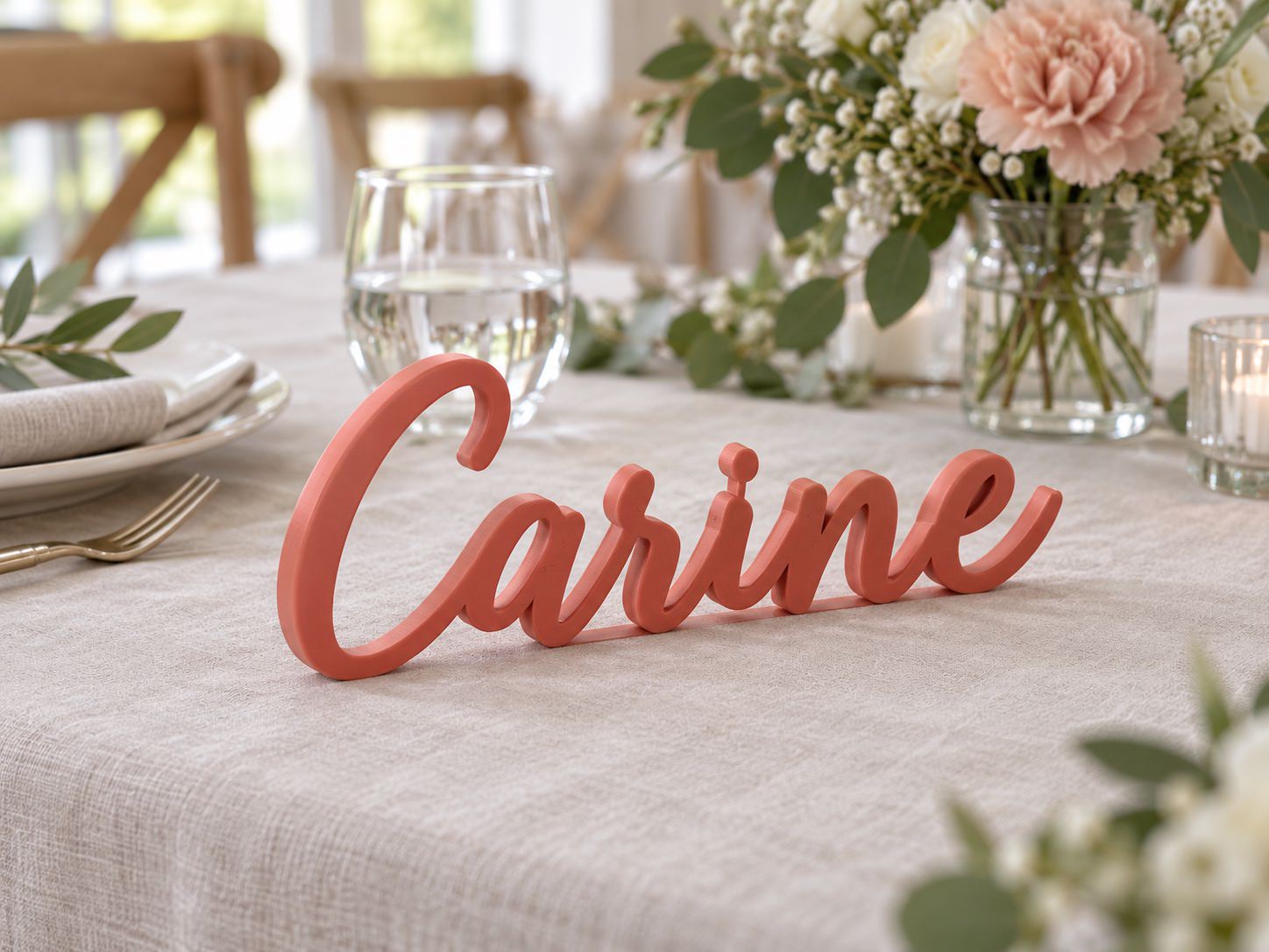 Prénom Carine imprimé en 3D en corail mat sur une table de réception