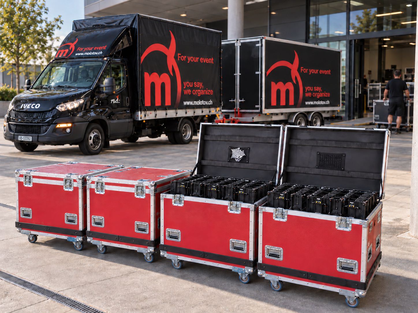 Des flight cases rouges ouverts et fermés devant le camion Molotov