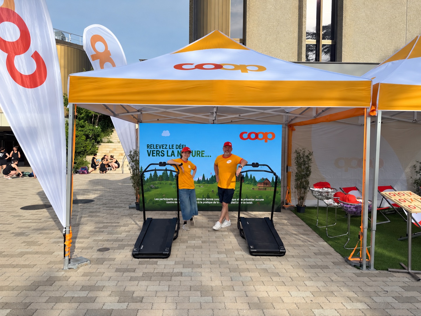 Équipe d’animation devant deux tapis de course sous une tente Coop