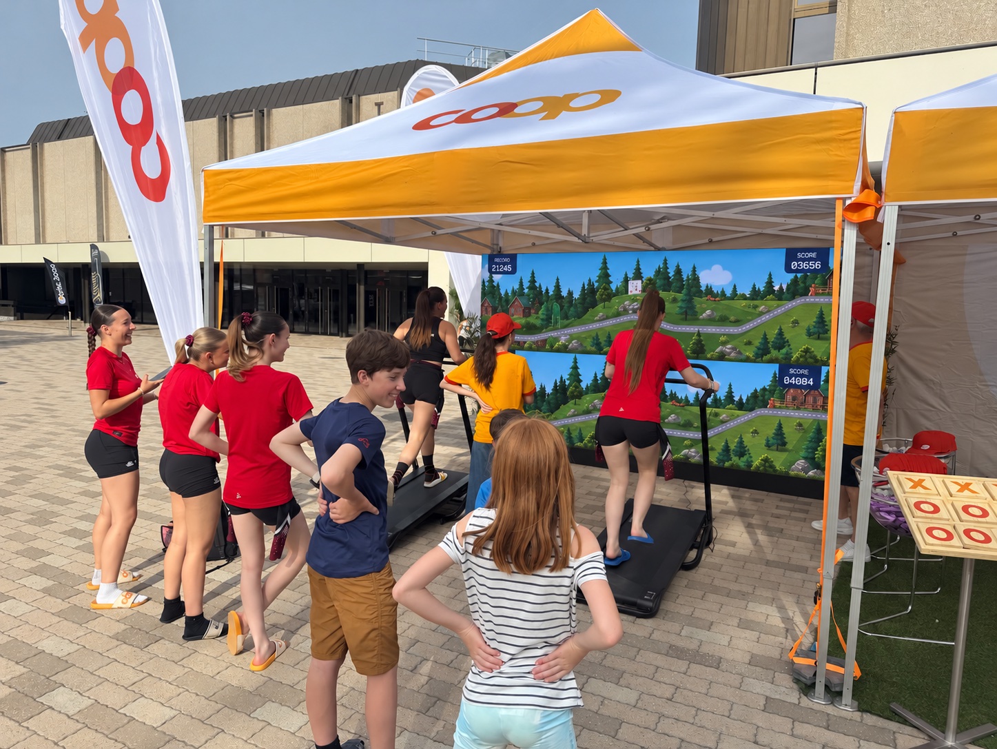 Participants sur tapis de course et spectateurs autour du stand
