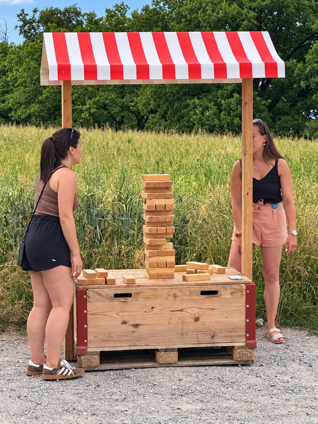 Deux participantes autour d’une tour de blocs en bois sur un stand de jeu en plein air