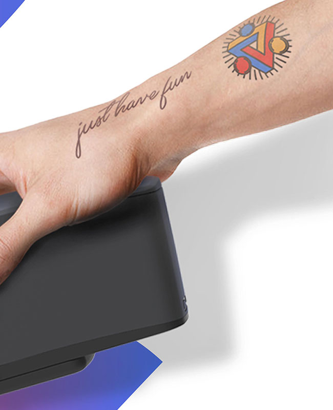 bras tatoué tenant une imprimante à tatouages éphémères - vaud valais genève fribourg